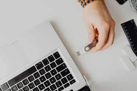 hand inserting a small USB wireless adapter into a laptop port hand inserting a small USB wireless adapter into a laptop port