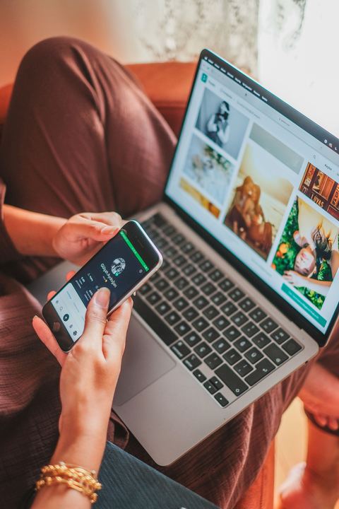 person using a laptop and phone connected over wireless internet person using a laptop and phone connected over wireless internet