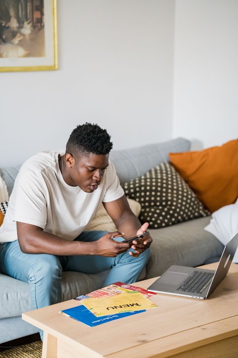 Man working with a laptop in a living room Man working with a laptop in a living room