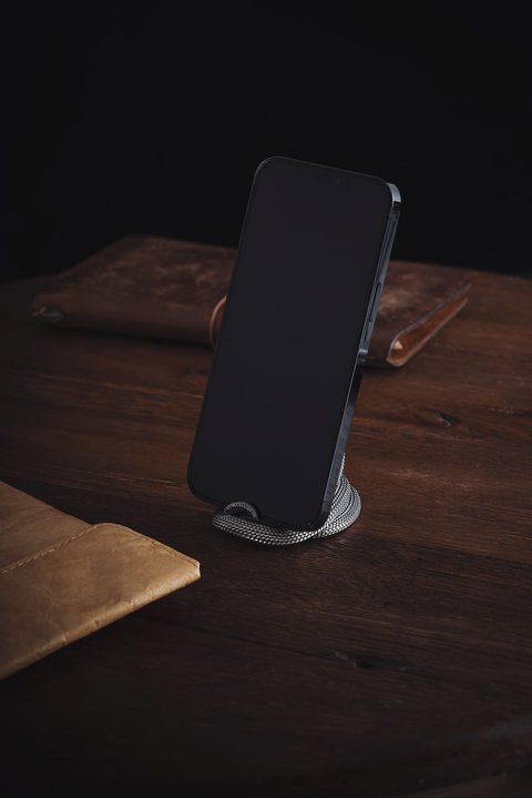 Smartphone resting on a silver charging stand