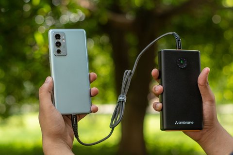 Hands holding a smartphone connected to a power bank Hands holding a smartphone connected to a power bank