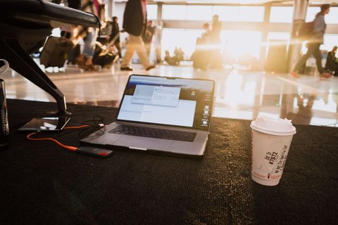 Laptop and coffee cup on the floor at an airport gate Laptop and coffee cup on the floor at an airport gate
