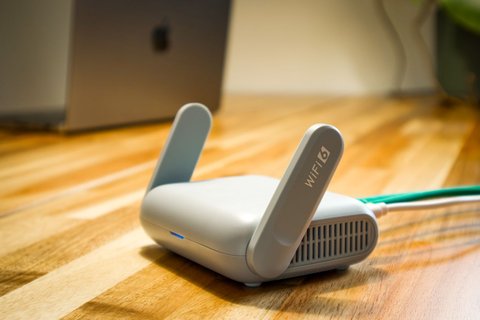 Modern dual band WiFi router on a wooden desk Modern dual band WiFi router on a wooden desk