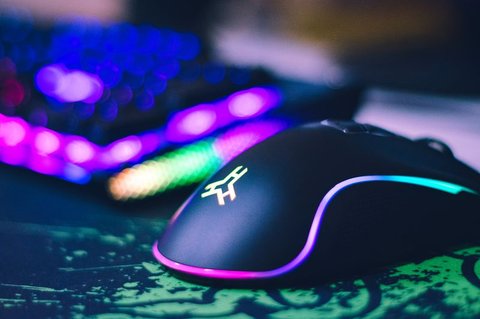 Close-up of a wired RGB gaming mouse with underglow lighting on a mat