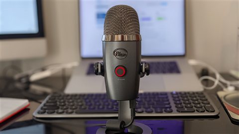 Close up of a USB microphone plugged into a laptop keyboard for recording Close up of a USB microphone plugged into a laptop keyboard for recording
