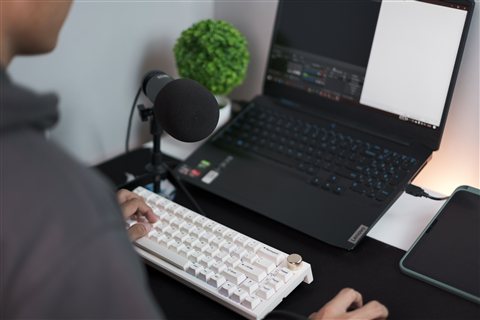 Person speaking into a desk microphone while recording audio content Person speaking into a desk microphone while recording audio content