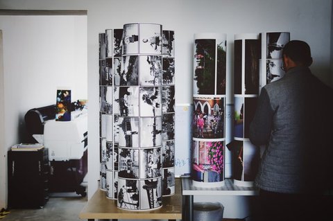 large format printer with printed photo rolls stacked beside it large format printer with printed photo rolls stacked beside it