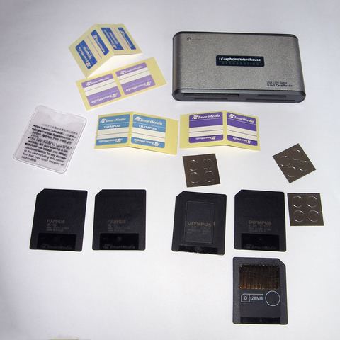 SmartMedia and other memory cards next to a card reader accessory