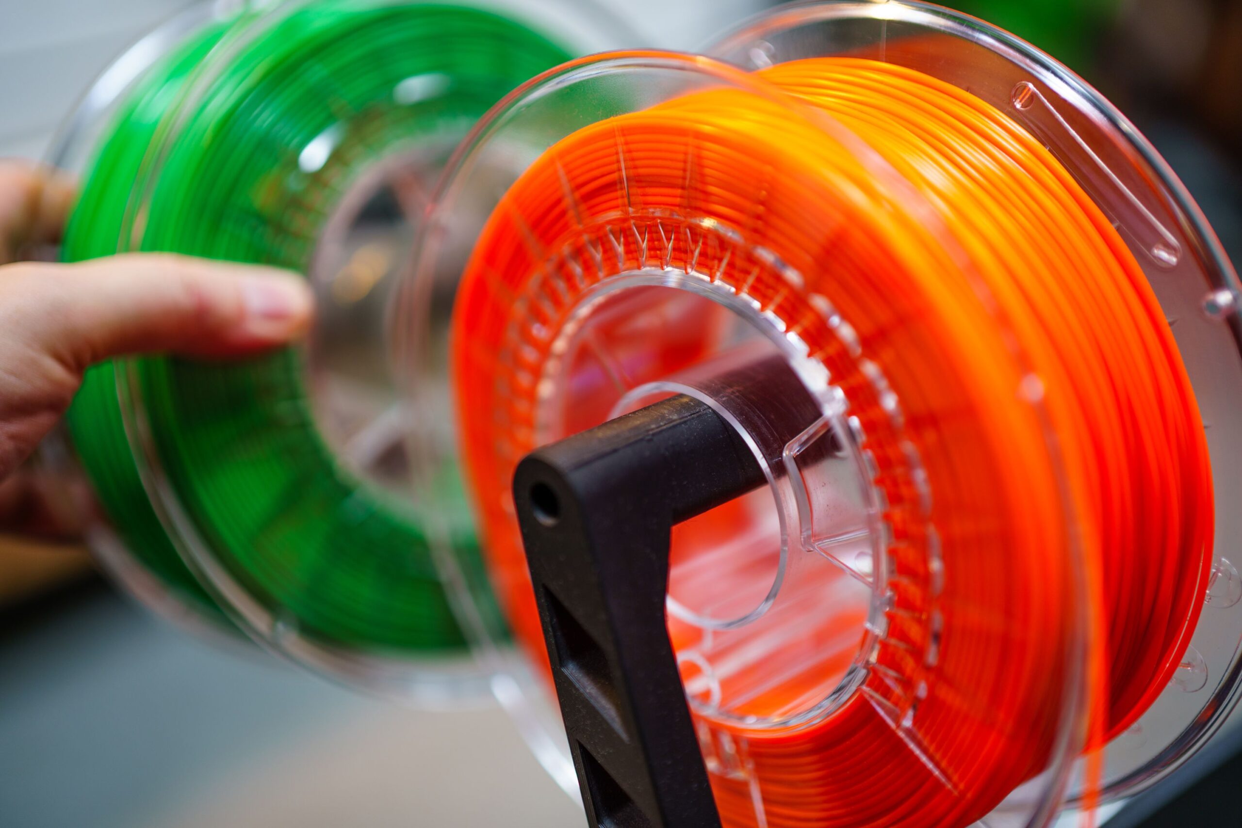 Spools of 3D printer filament in bright colors on a workbench Spools of 3D printer filament in bright colors on a workbench