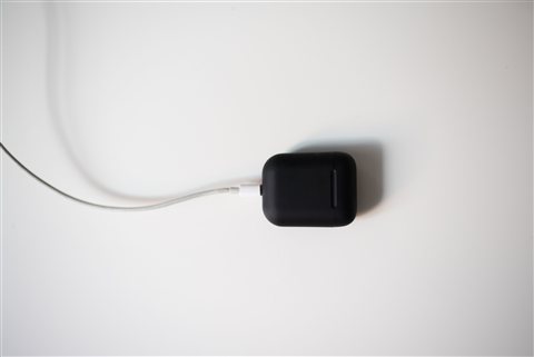 Small black wireless electronics adapter sitting on a colorful surface Small black wireless electronics adapter sitting on a colorful surface