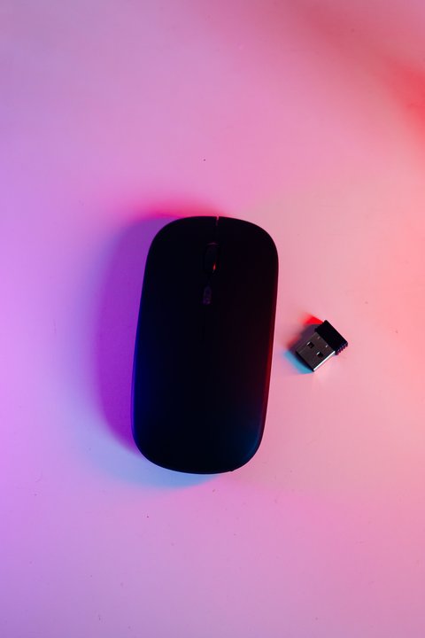 Small USB Bluetooth receiver dongle placed next to wireless computer mouse Small USB Bluetooth receiver dongle placed next to wireless computer mouse