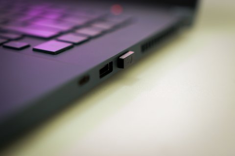 Close-up of USB dongle inserted into laptop side port for pairing Close-up of USB dongle inserted into laptop side port for pairing