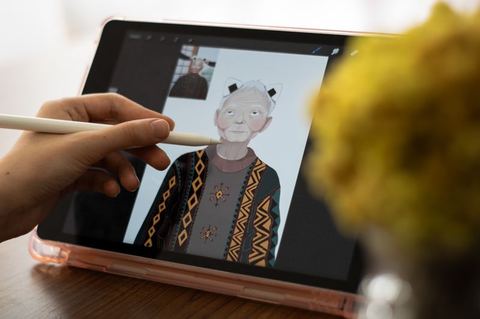 hand using a stylus pen on a digital drawing tablet