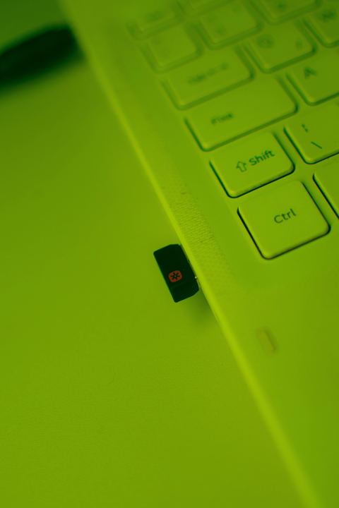 Small black USB wireless network adapter plugged into a laptop port