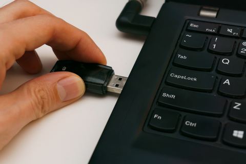 Compact USB dongle plugged into the side of a laptop Compact USB dongle plugged into the side of a laptop
