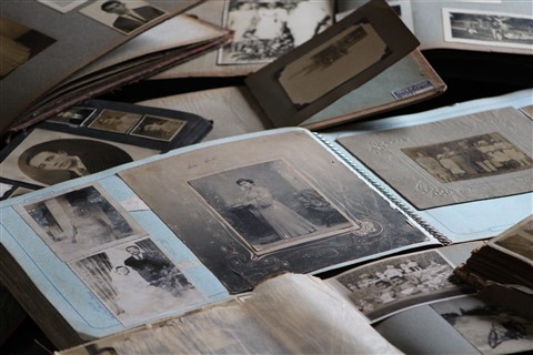Stack of old printed photographs and albums ready to be digitized with a scanner