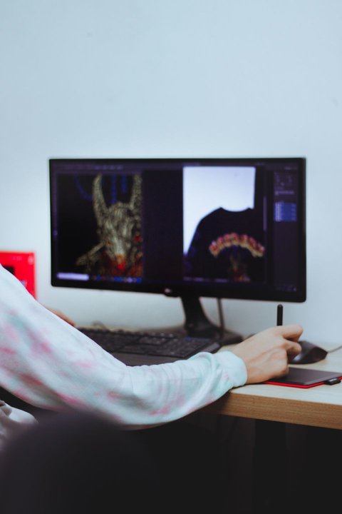 Digital artist working at a desk with a graphics tablet and monitor Digital artist working at a desk with a graphics tablet and monitor
