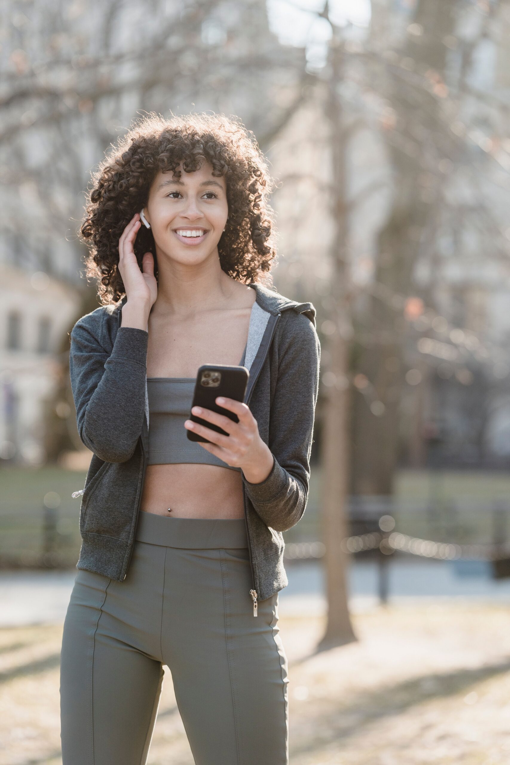 Woman outdoors taking a phone call using a wireless earbud