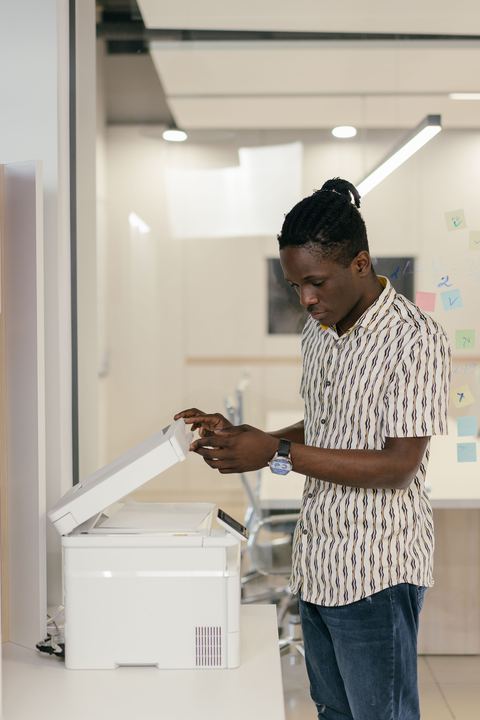 Person lifting scanner lid to place document for digitizing Person lifting scanner lid to place document for digitizing