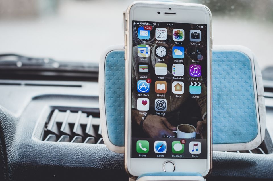 Smartphone mounted on a car dashboard showing home screen Smartphone mounted on a car dashboard showing home screen