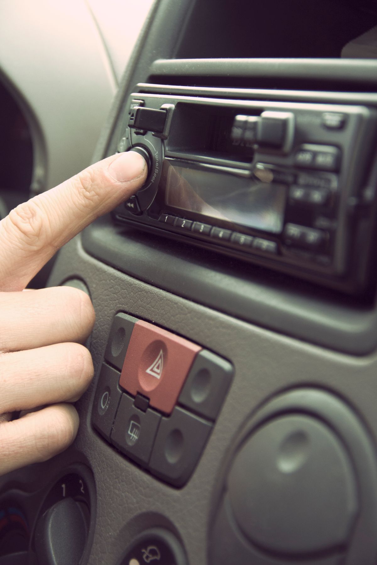 Finger adjusting tuning dial on a Kenwood style car stereo head unit Finger adjusting tuning dial on a Kenwood style car stereo head unit