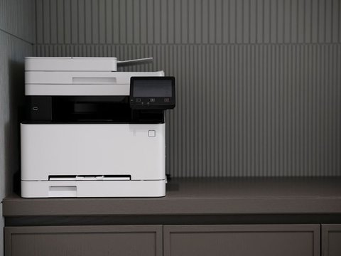 White all-in-one printer set up on an office cabinet with control panel visible White all-in-one printer set up on an office cabinet with control panel visible