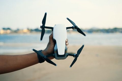 Hand holding a white hexacopter drone similar to the Yuneec Typhoon H outdoors Hand holding a white hexacopter drone similar to the Yuneec Typhoon H outdoors