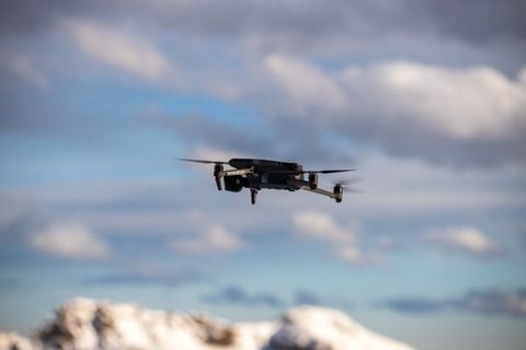 Drone in flight over a grassy field at sunset showing outdoor GPS operation Drone in flight over a grassy field at sunset showing outdoor GPS operation